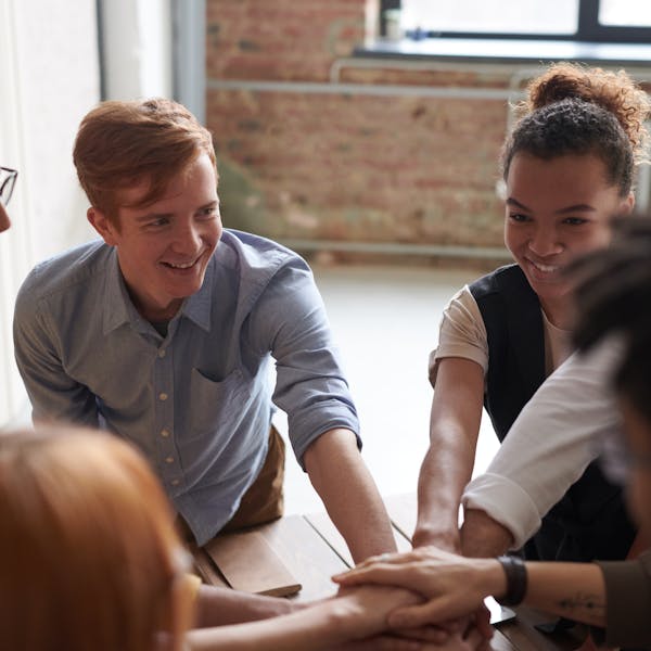 A group session in an addiction recovery program where men and women in their 20's and 30's sit in a circle talking.