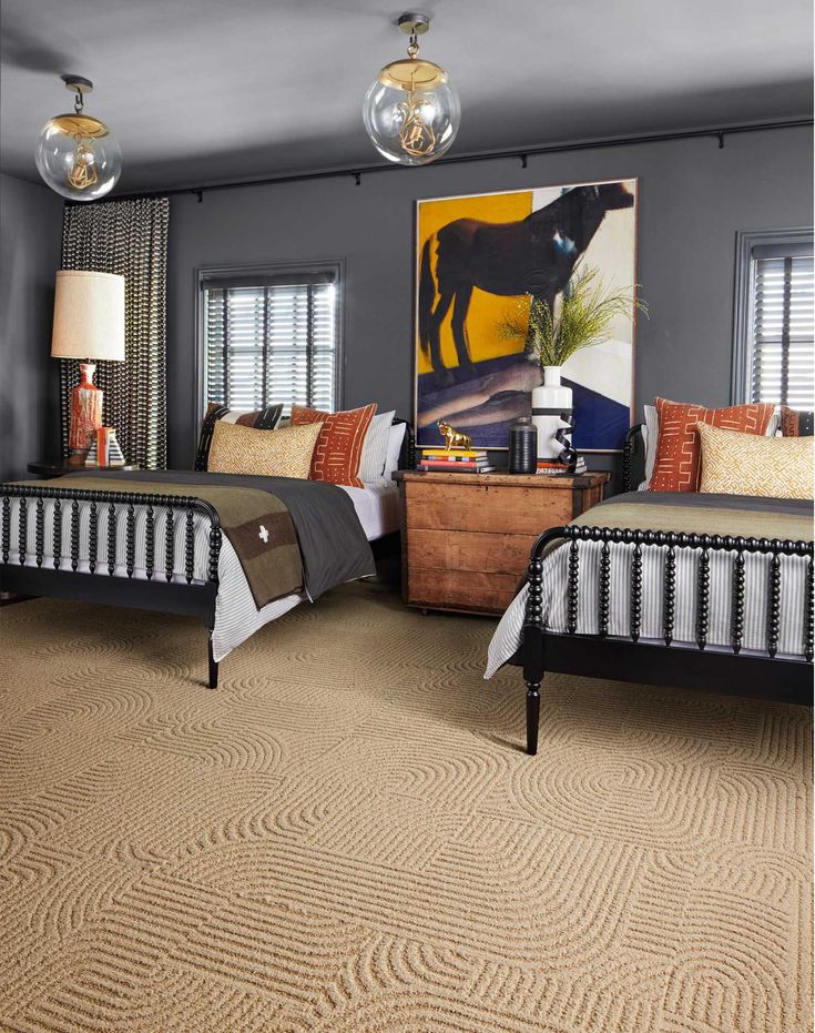 2 nicely furnished double beds in a large bedroom in Philadelphia. With los of pillows and pleasant artowork in the room.